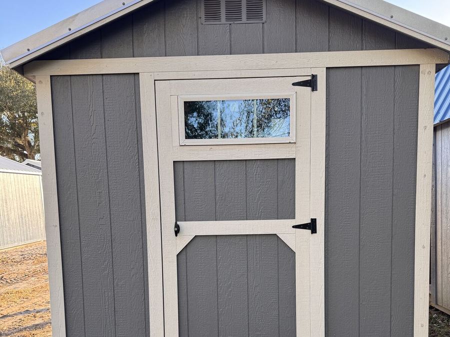Gray utility shed with cream trim